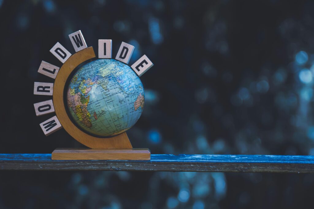 A vintage globe on a wooden stand with 'WORLDWIDE' letters, symbolizing global connection and geography.